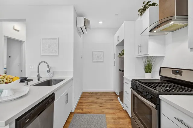 a kitchen with stainless steel appliances granite countertop a sink stove and cabinets
