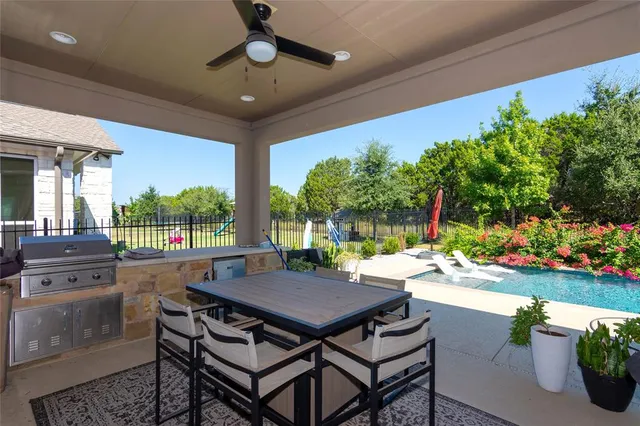 a view of a patio with a dining table and chairs with a garden