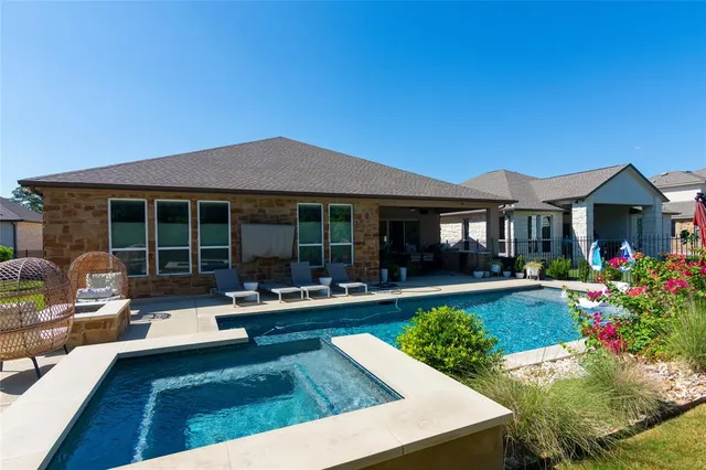 a front view of a house with swimming pool and porch with furniture