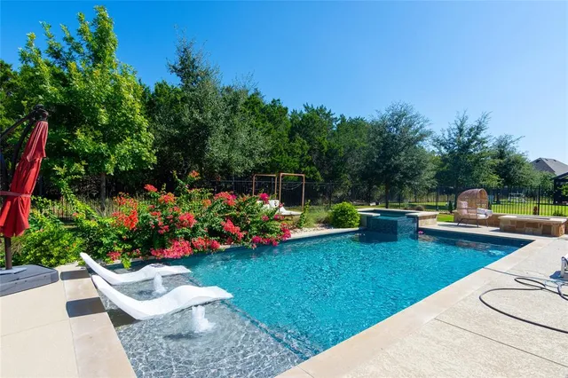 a view of a backyard with swimming pool and plants