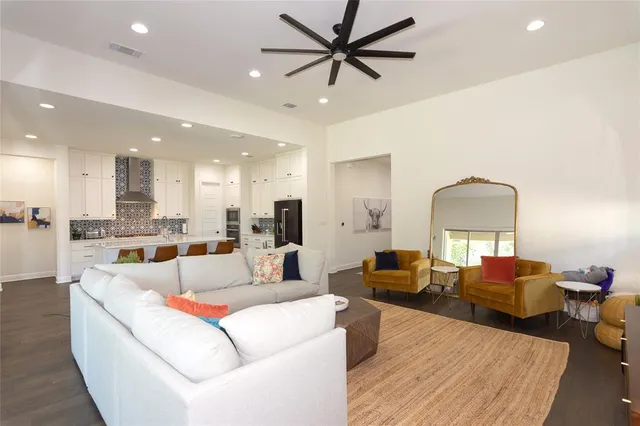 a living room with furniture and a view of kitchen