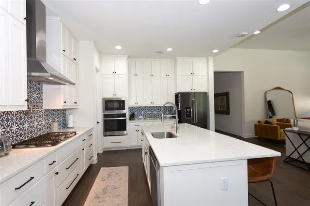 a kitchen with stainless steel appliances kitchen island granite countertop a refrigerator and a stove top oven