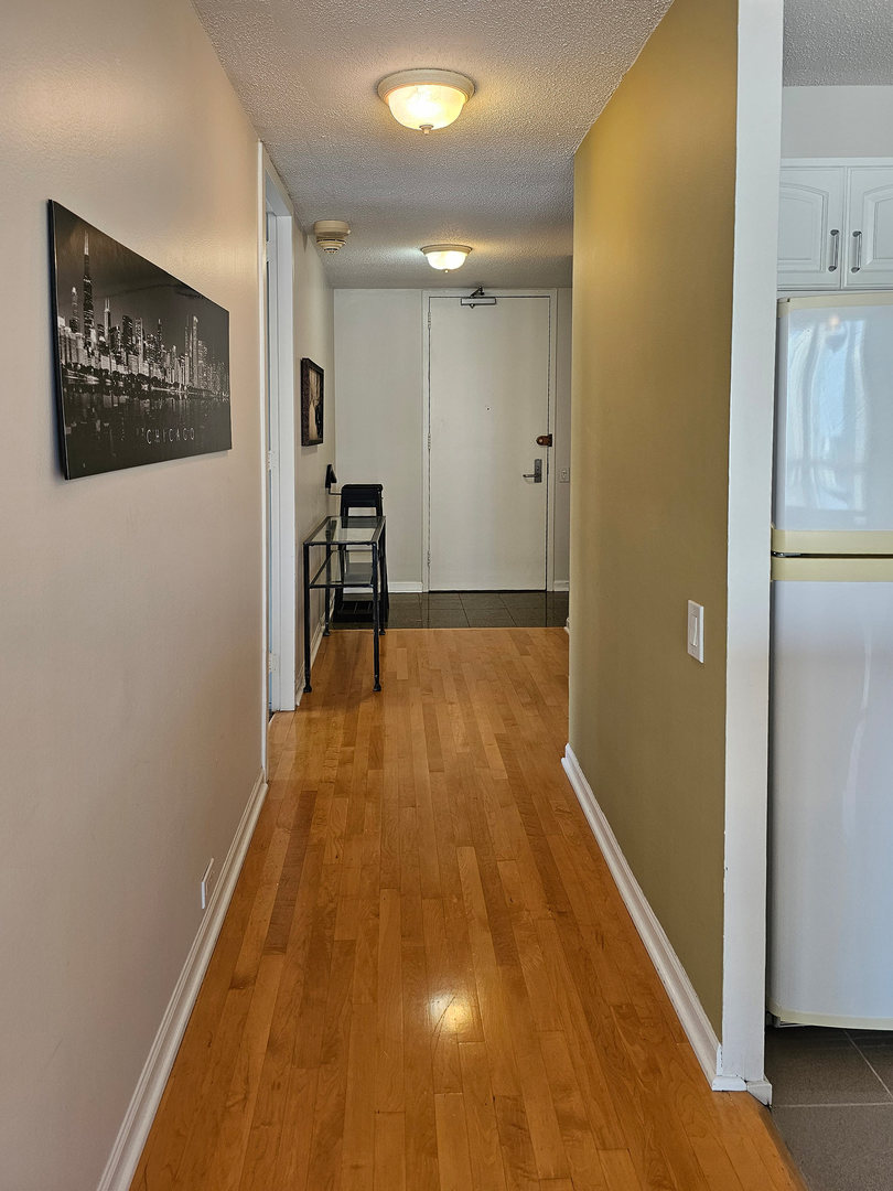 405 North Wabash Avenue, Unit 2613 Chicago, IL 60611 - Photo 11 of 24 a view of a hallway with wooden floor and a refrigerator