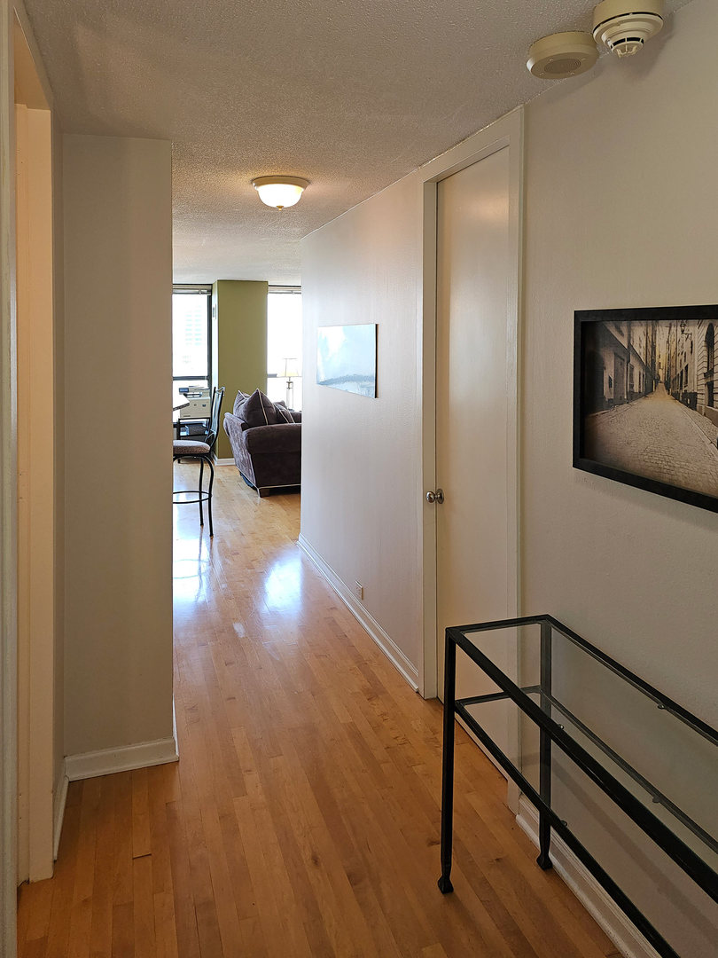 405 North Wabash Avenue, Unit 2613 Chicago, IL 60611 - Photo 3 of 24 a view of a hallway with wooden floor and furniture