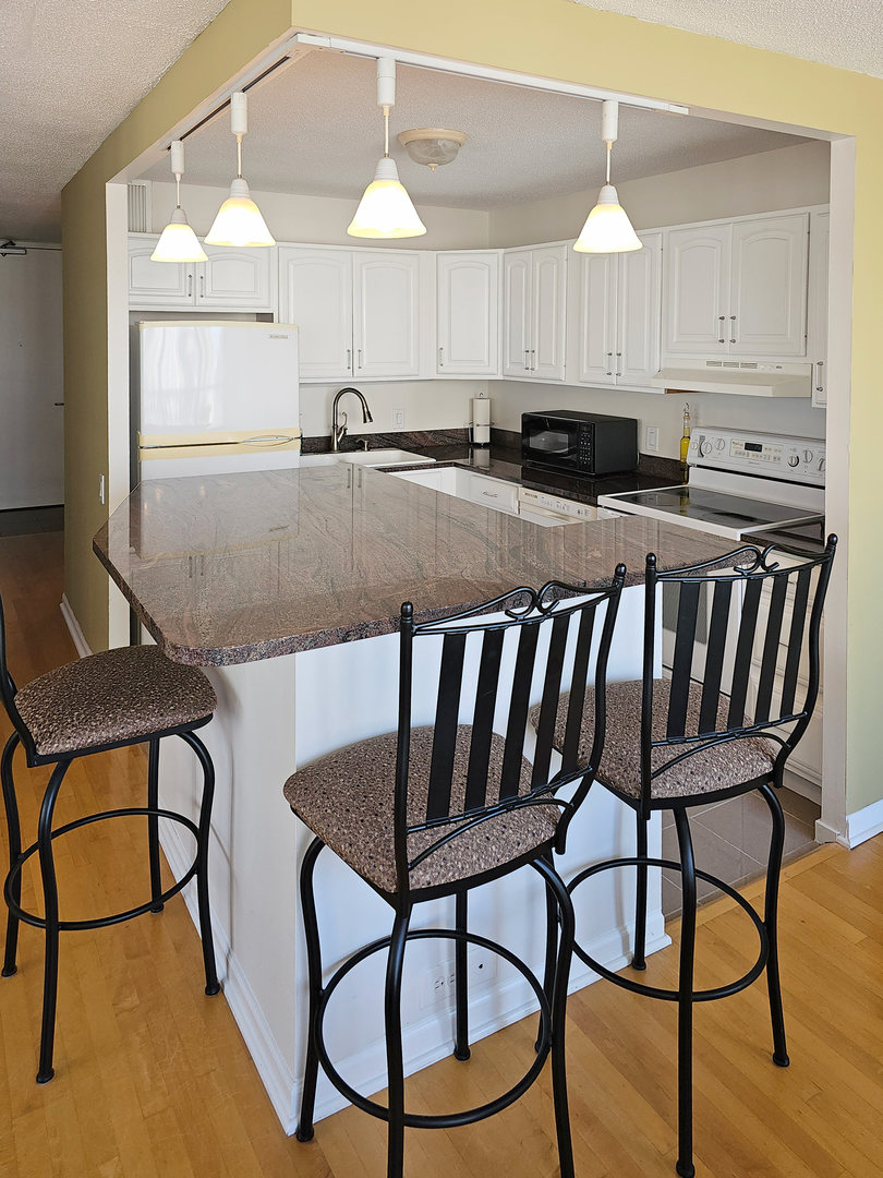 405 North Wabash Avenue, Unit 2613 Chicago, IL 60611 - Photo 4 of 24 a kitchen with a table chairs and a sink