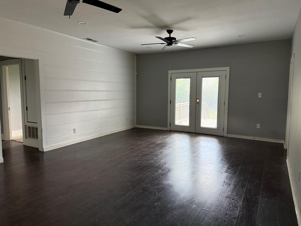 202 4th Street Joshua, TX 76058 - Photo 12 of 39 an empty room with wooden floor chandelier fan and windows