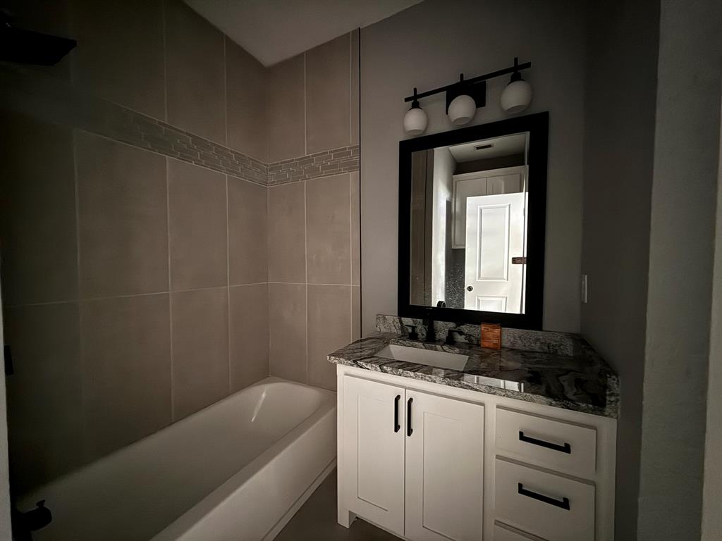 202 4th Street Joshua, TX 76058 - Photo 19 of 39 a bathroom with a granite countertop sink a toilet and bathtub