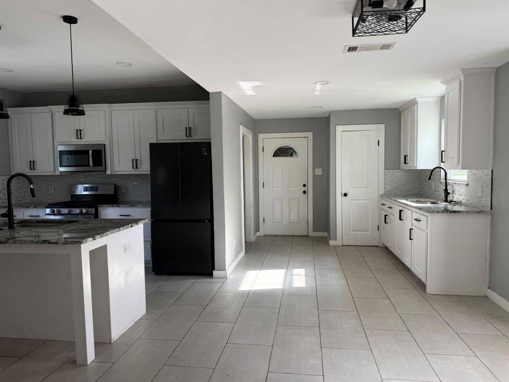 202 4th Street Joshua, TX 76058 - Photo 2 of 39 a kitchen with kitchen island granite countertop a refrigerator a sink and a stove