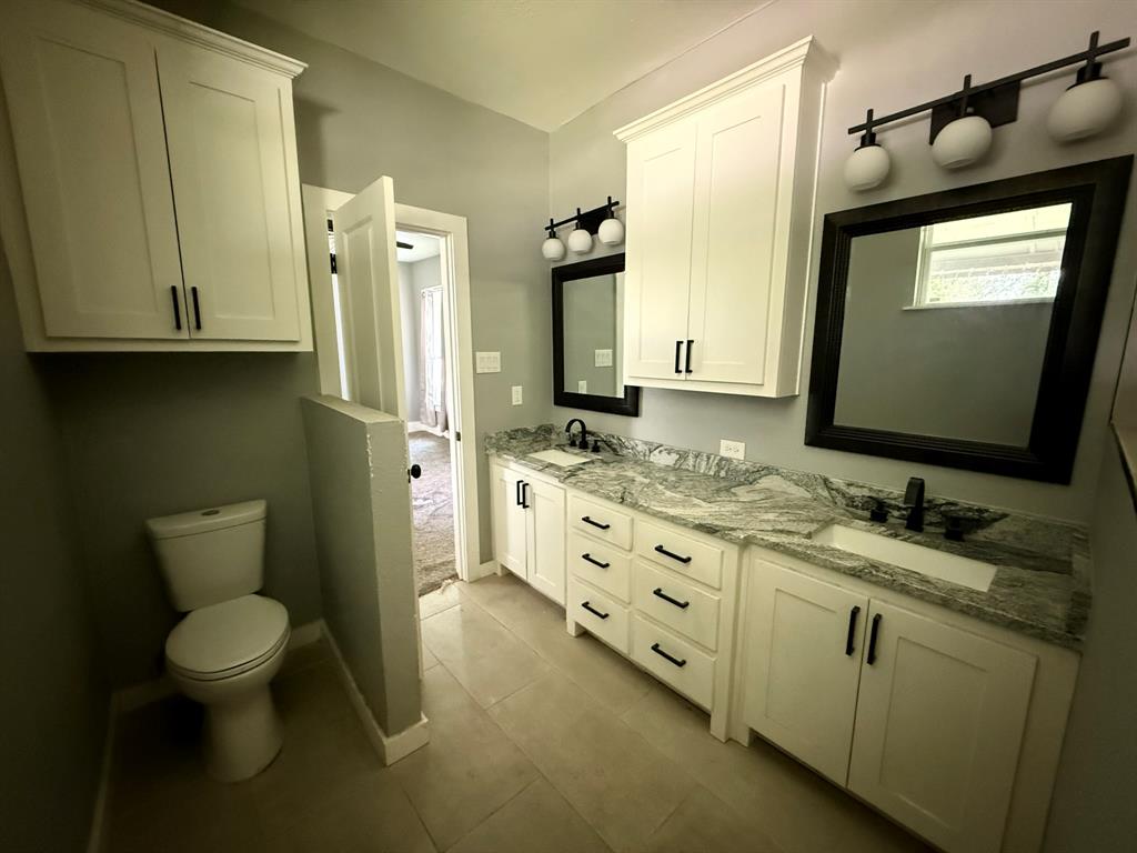 202 4th Street Joshua, TX 76058 - Photo 26 of 39 a bathroom with double vanity sink a mirror and a toilet