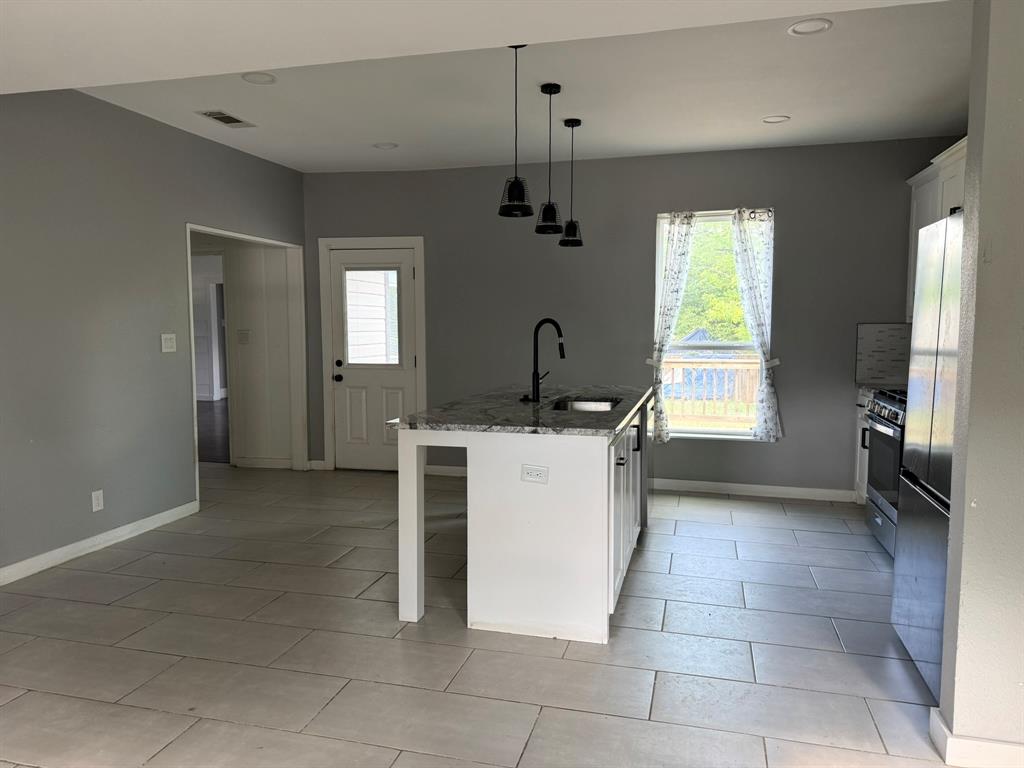 202 4th Street Joshua, TX 76058 - Photo 5 of 39 a kitchen that has a sink and a stove in it