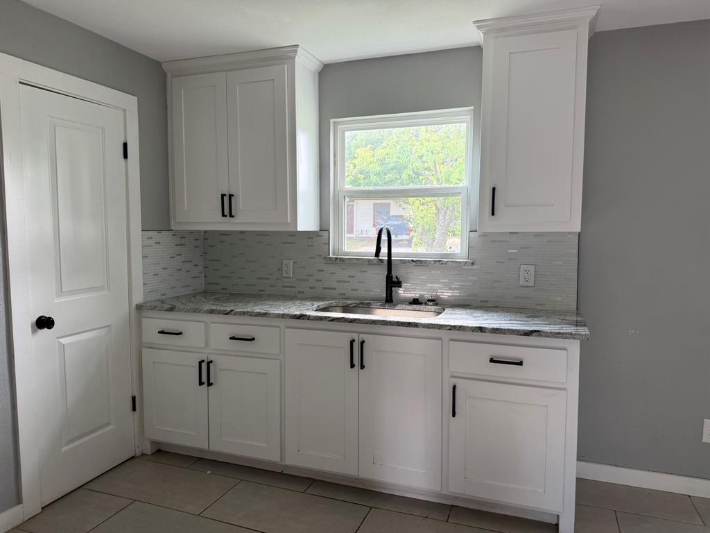 202 4th Street Joshua, TX 76058 - Photo 7 of 39 a kitchen with granite countertop white cabinets and sink
