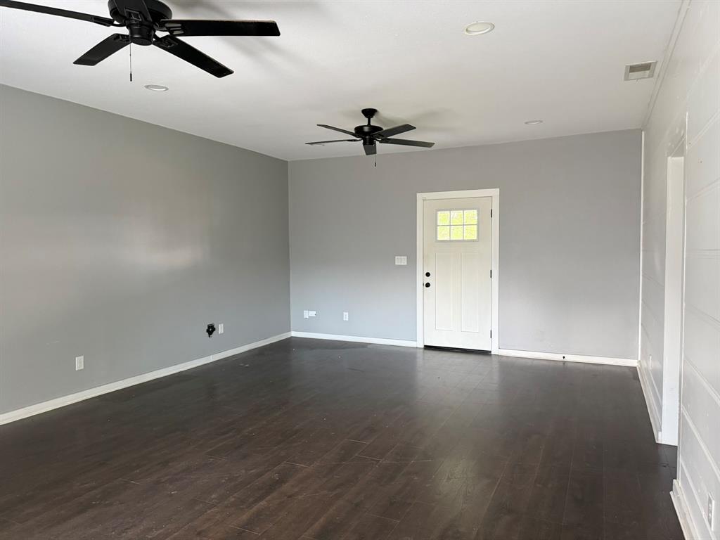 202 4th Street Joshua, TX 76058 - Photo 10 of 39 an empty room with a ceiling fan and wooden floor