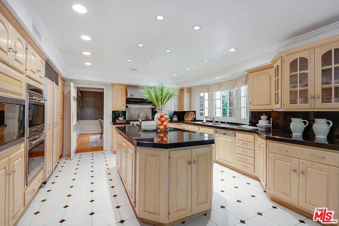 11610 Bellagio Road Los Angeles, CA 90049 - Photo 19 of 46 a kitchen with sink a stove and cabinets
