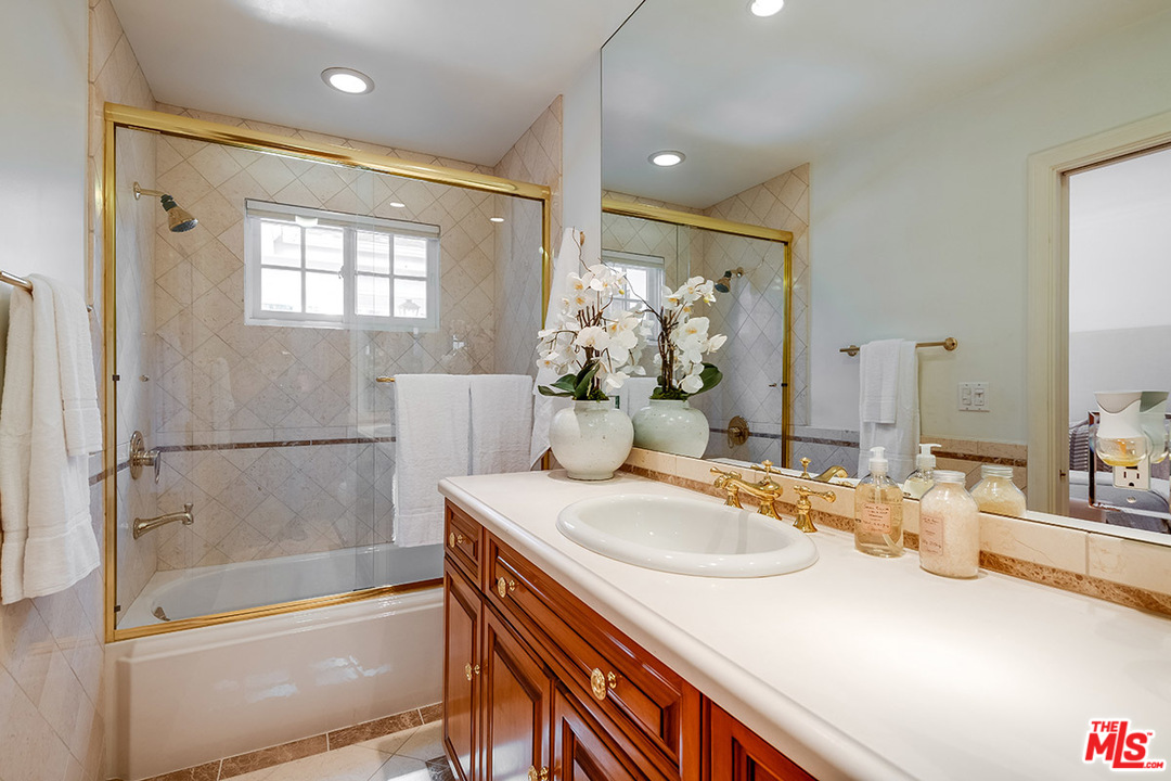 11610 Bellagio Road Los Angeles, CA 90049 - Photo 23 of 46 a bathroom with a bathtub sink and mirror