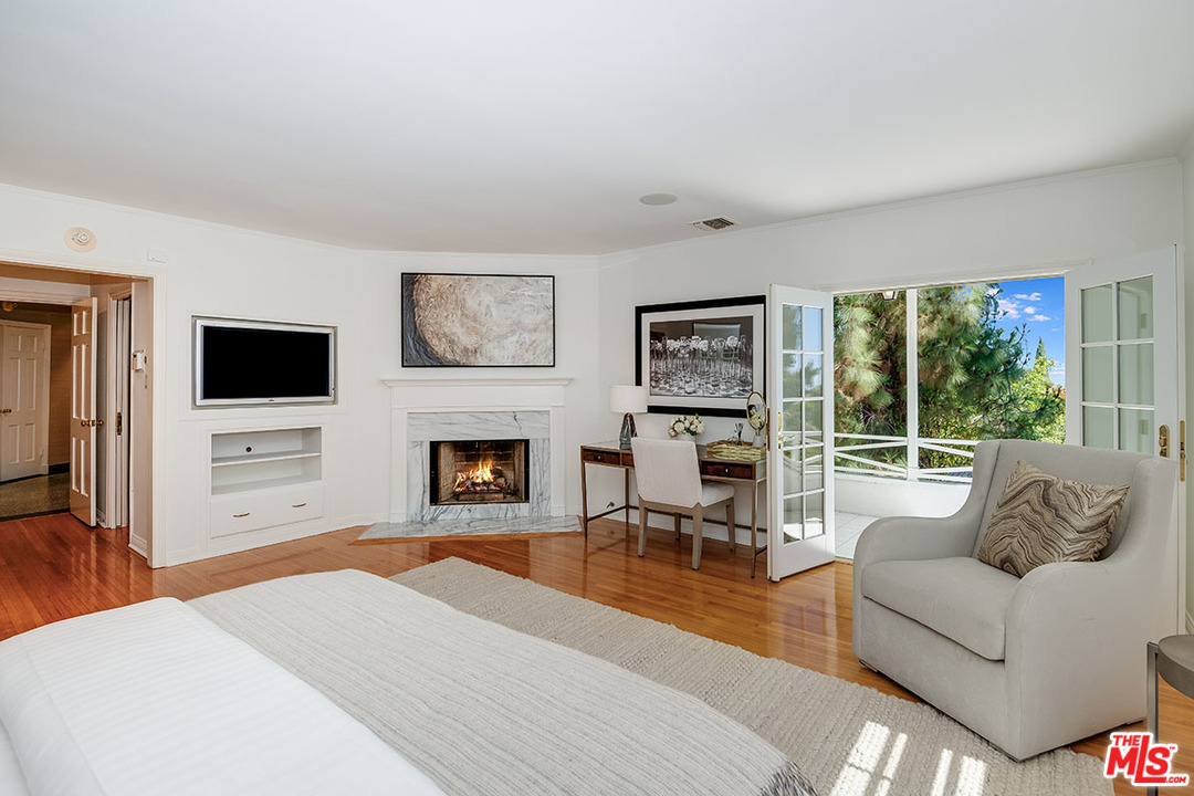 11610 Bellagio Road Los Angeles, CA 90049 - Photo 28 of 46 a living room with furniture tv and a fireplace