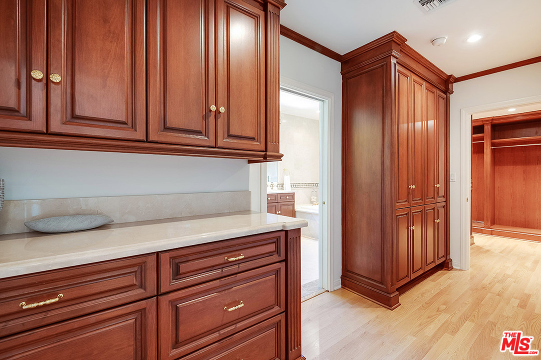 11610 Bellagio Road Los Angeles, CA 90049 - Photo 29 of 46 a kitchen with granite countertop cabinets and black appliances
