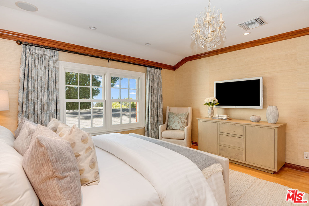 11610 Bellagio Road Los Angeles, CA 90049 - Photo 33 of 46 a bedroom with a bed television on desk and a window