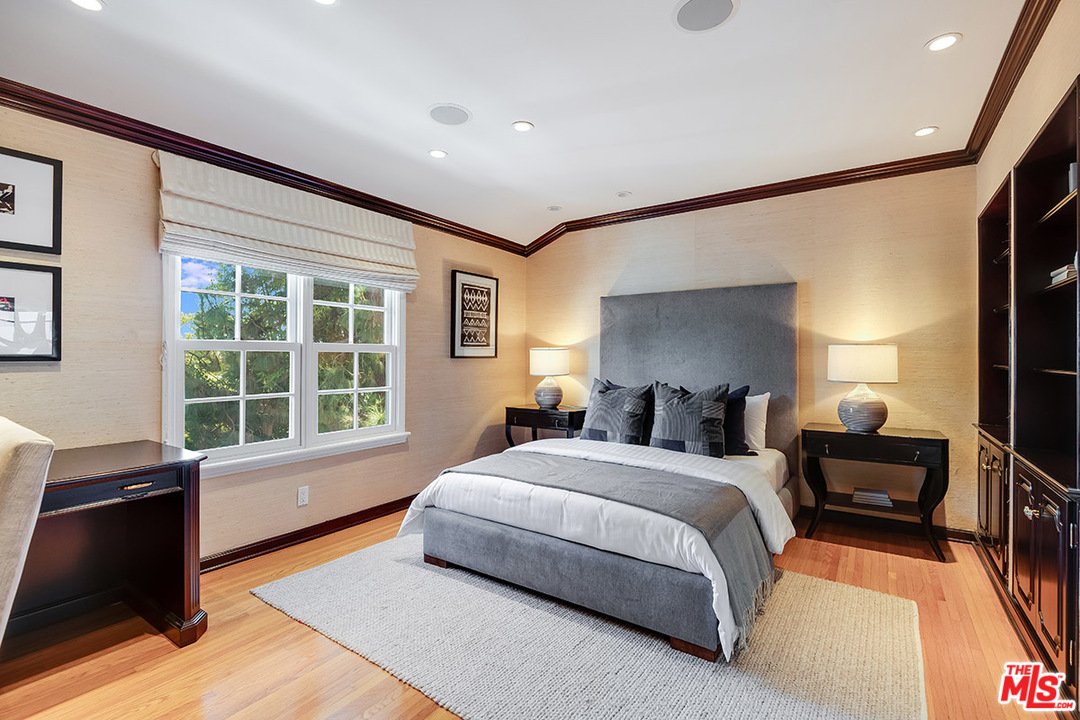 11610 Bellagio Road Los Angeles, CA 90049 - Photo 34 of 46 a spacious bedroom with a bed and a dresser next to a window