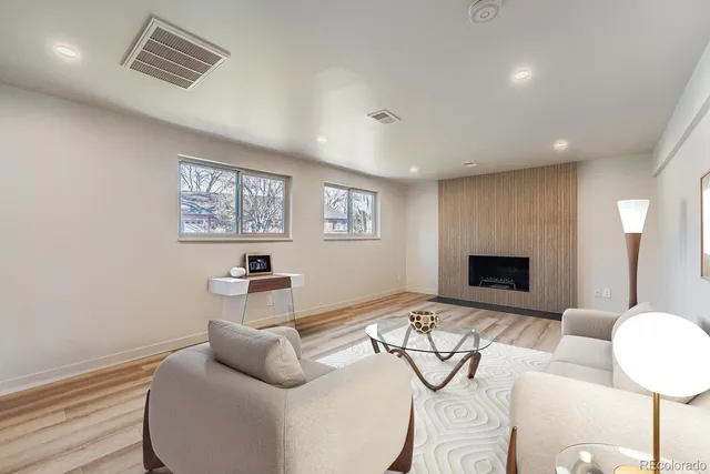 an empty room with windows and fireplace