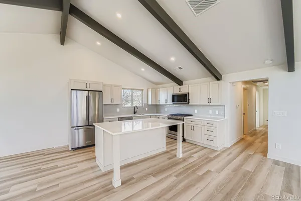 a kitchen with cabinets and wooden floor