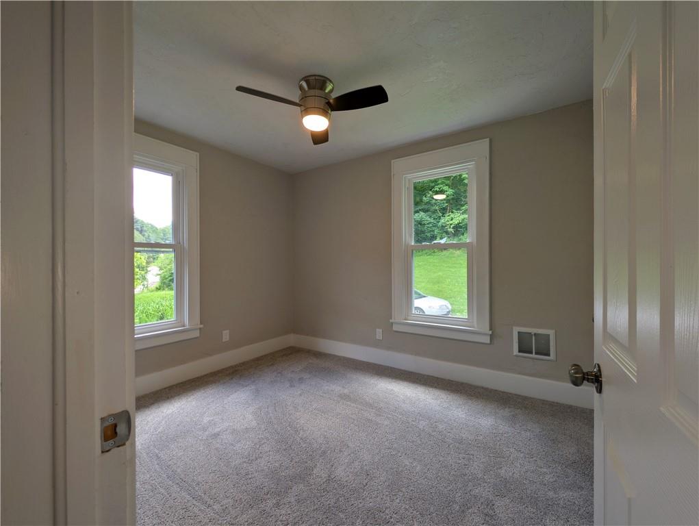 555 Steel Hill Road Mount Morris, PA 15349 - Photo 11 of 19 an empty room with a window and a ceiling fan