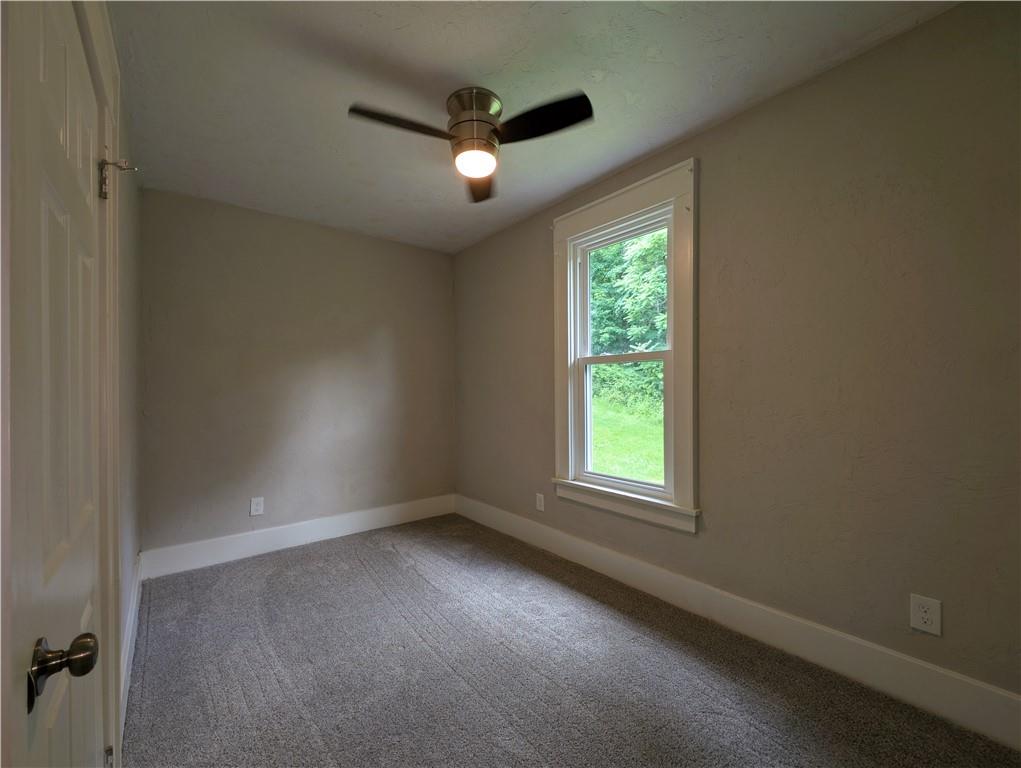 555 Steel Hill Road Mount Morris, PA 15349 - Photo 13 of 19 an empty room with a window and a ceiling fan