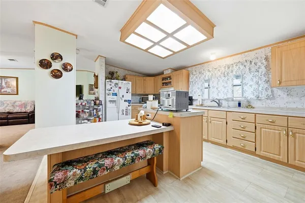 a open kitchen with stainless steel appliances granite countertop a stove a sink dishwasher and a refrigerator with wooden floor