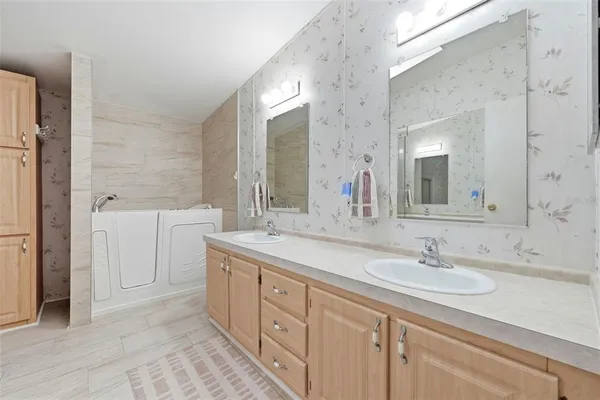 a spacious bedroom with a bed and dresser with mirror