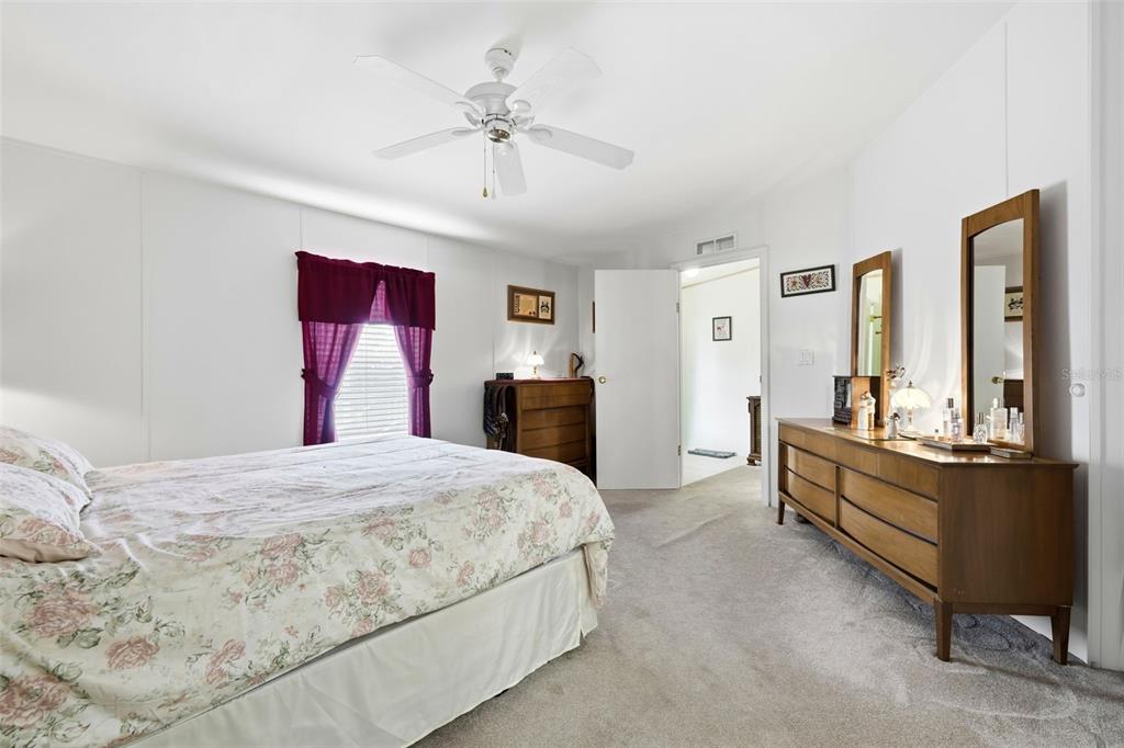630 Otto Polk Road Frostproof, FL 33843 - Photo 28 of 44 a spacious bedroom with a bed and dresser with mirror