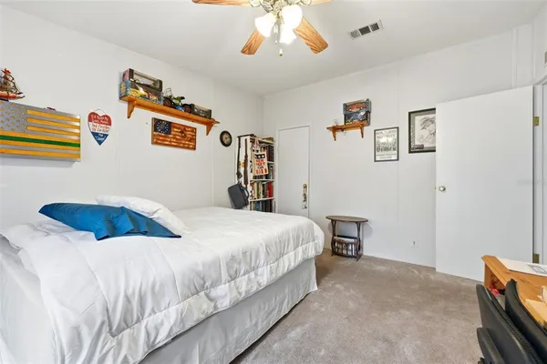 a spacious bedroom with a bed and a book shelf