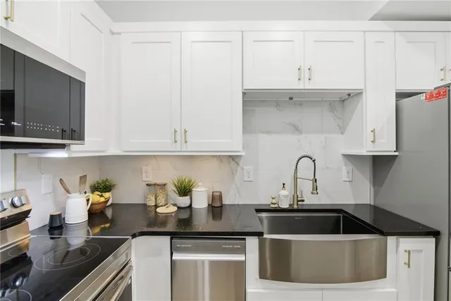 a kitchen with stainless steel appliances granite countertop a sink a stove and cabinets