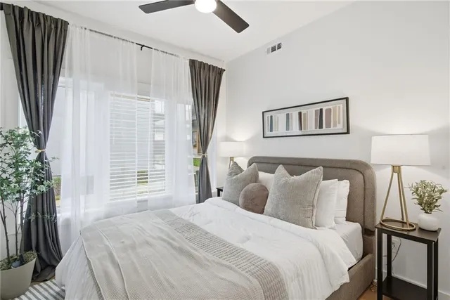 a bedroom with a large bed and a potted plant