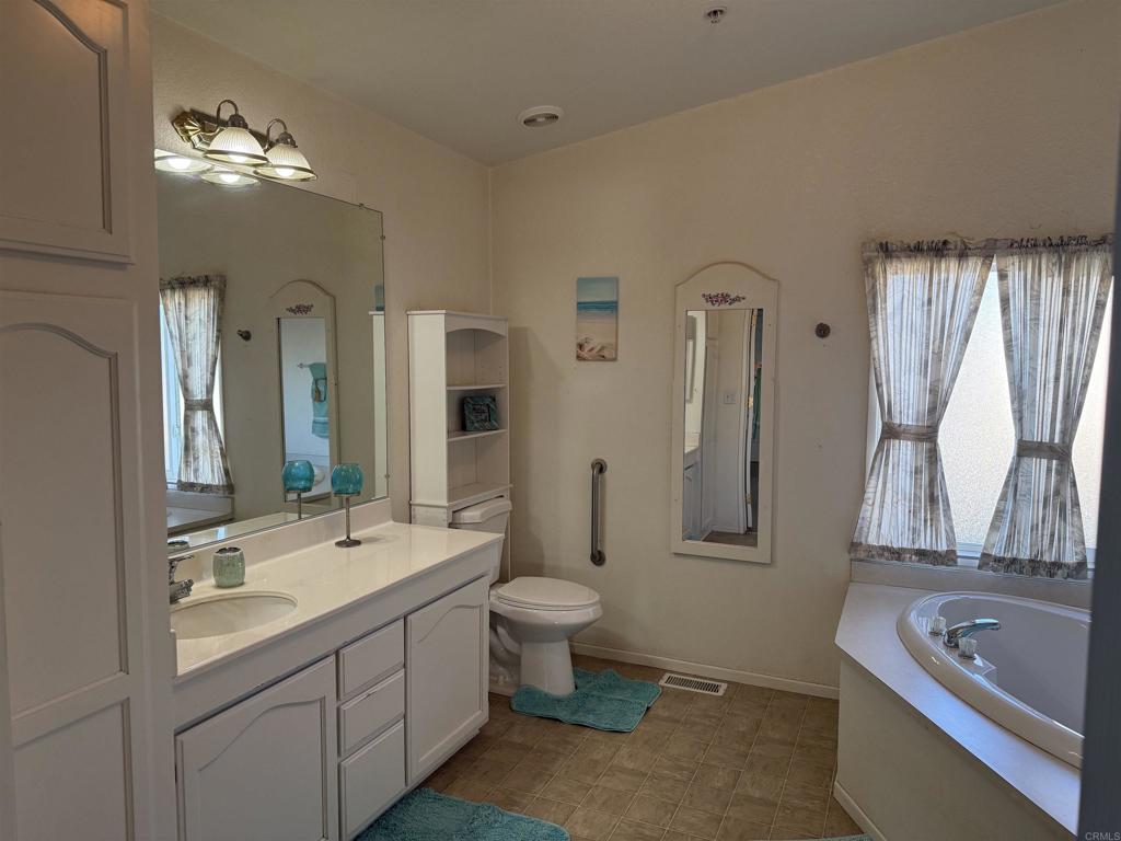 37697 Montezuma Valley Road Ranchita, CA 92066 - Photo 29 of 47 a bathroom with a double vanity sink and mirror with bathtub