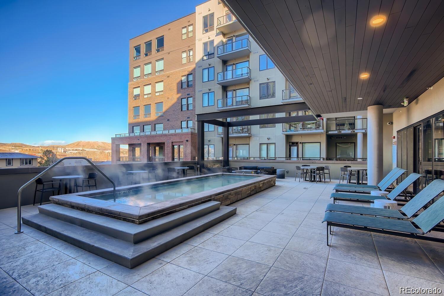 20 Wilcox Street, Unit 518 Castle Rock, CO 80104 - Photo 18 of 34 a view of a patio with couches table and chairs with wooden floor