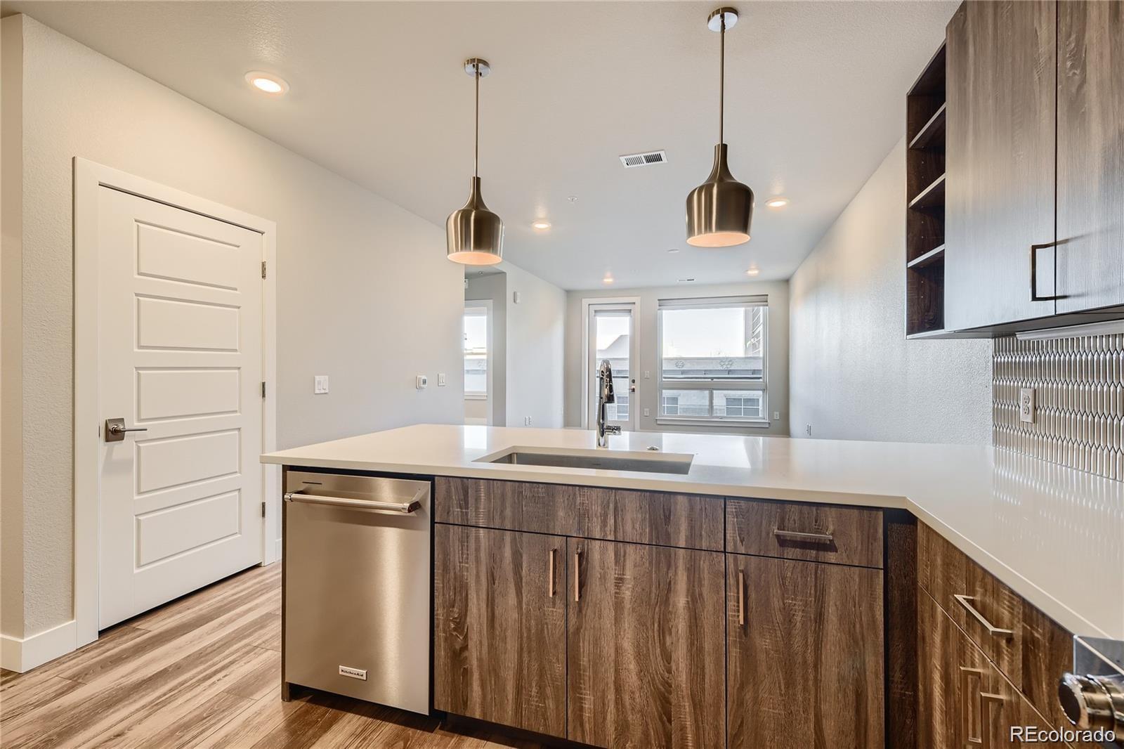 20 Wilcox Street, Unit 518 Castle Rock, CO 80104 - Photo 2 of 34 a kitchen with kitchen island a sink stainless steel appliances and cabinets