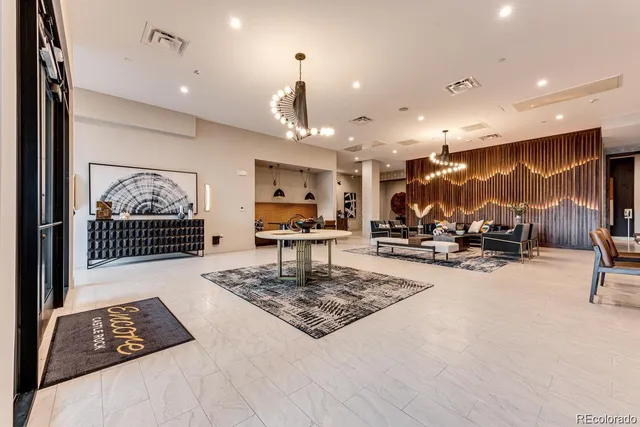 a living room with furniture kitchen view and a chandelier
