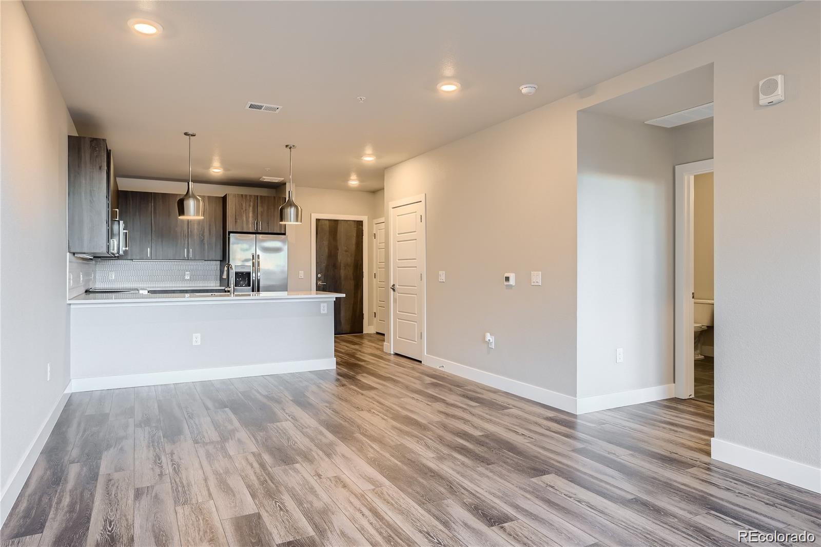 20 Wilcox Street, Unit 518 Castle Rock, CO 80104 - Photo 3 of 34 a view of kitchen with kitchen island wooden floor center island and stainless steel appliances