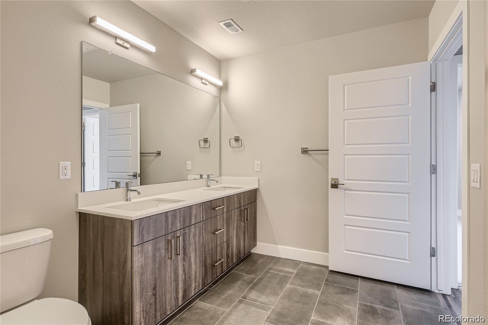 20 Wilcox Street, Unit 518 Castle Rock, CO 80104 - Photo 6 of 34 a bathroom with a sink a toilet a mirror and vanity