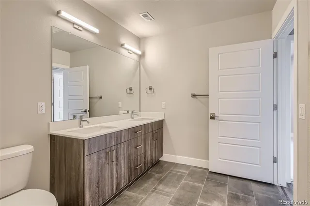 a bathroom with a sink a toilet a mirror and vanity