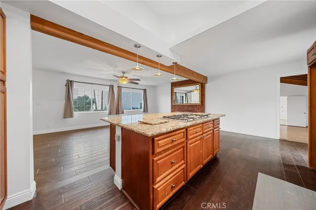 a kitchen with stainless steel appliances kitchen island a hardwood floor and a sink