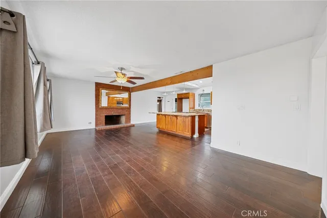a living room with stainless steel appliances kitchen island granite countertop a stove and a fireplace