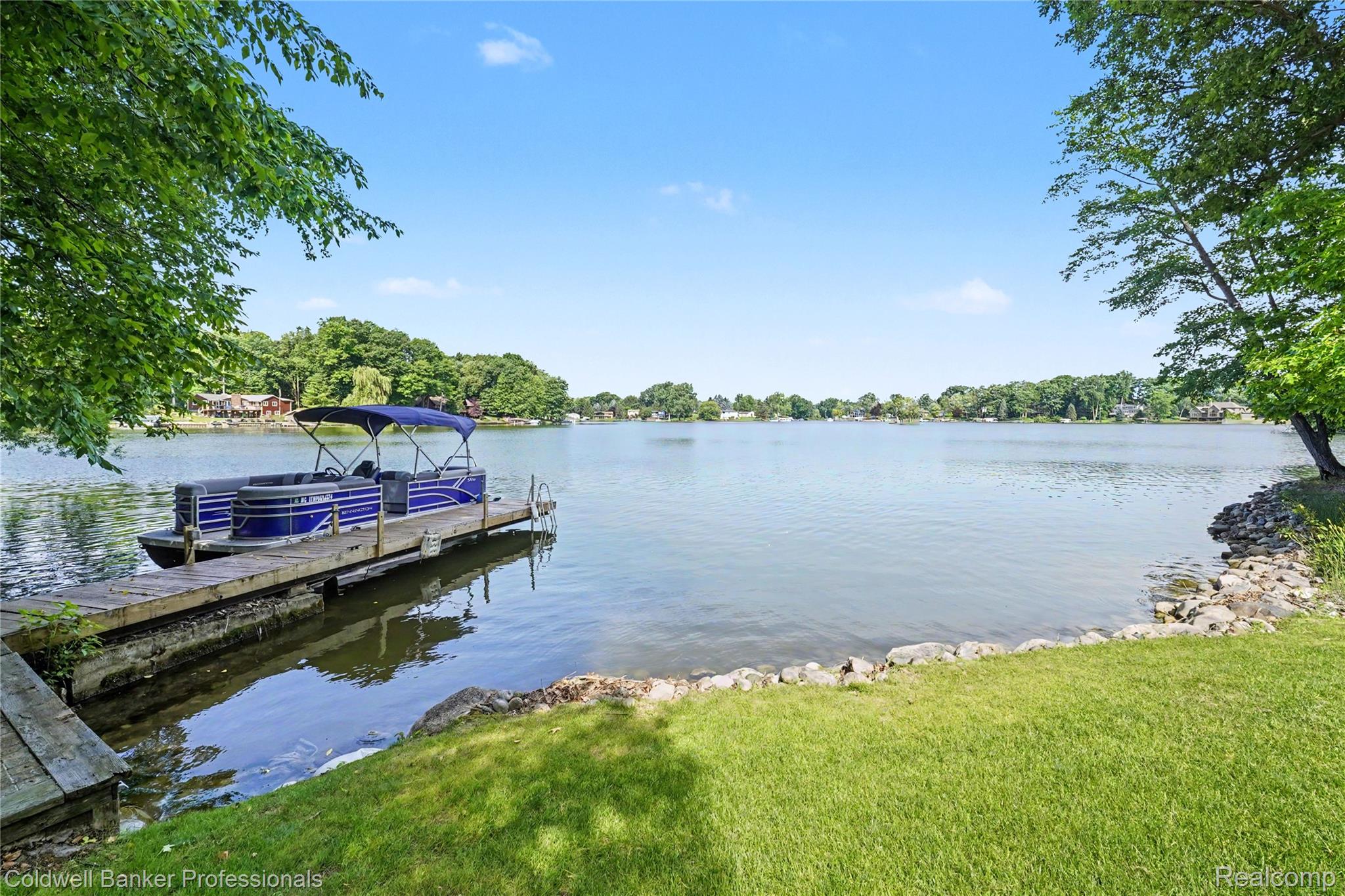 3583 Mitchell Road Metamora, MI 48455 - Photo 50 of 58 Expansive lake frontage featuring a private wooden dock, green lawn, and mature trees