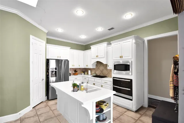 a kitchen with refrigerator and cabinets