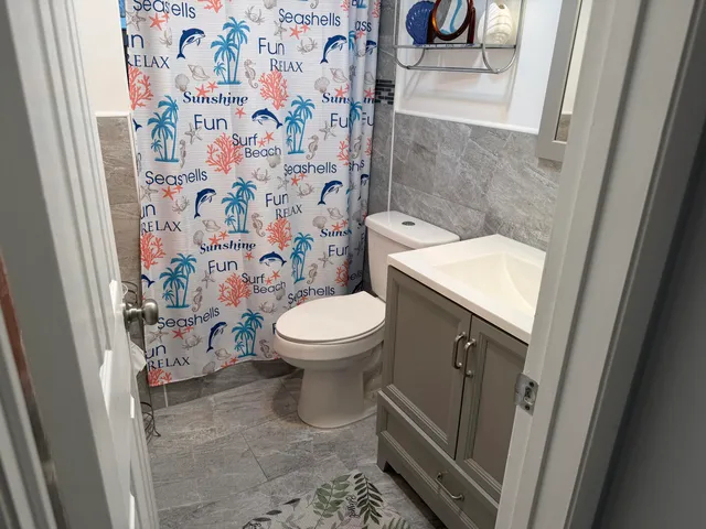 a bathroom with a sink a toilet and shower curtain