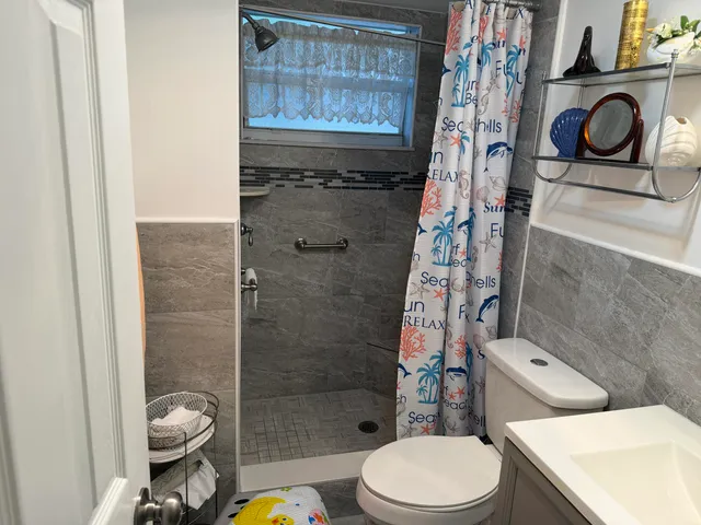 a white toilet sitting next to a shower curtain