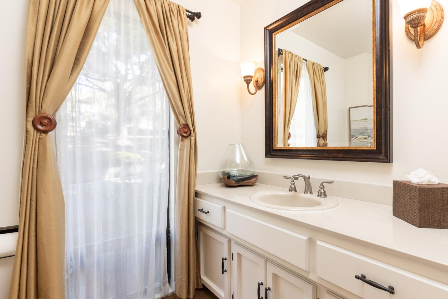 1424 Oleada Road Pebble Beach, CA 93953 - Photo 17 of 30 a bathroom with a sink a mirror a vanity and a shower