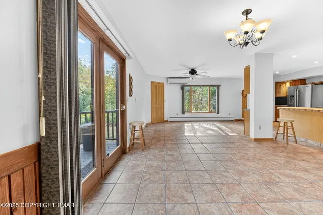 a view of entryway with a chandelier fan and windows
