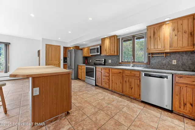 a kitchen with stainless steel appliances granite countertop a stove a sink dishwasher and a refrigerator