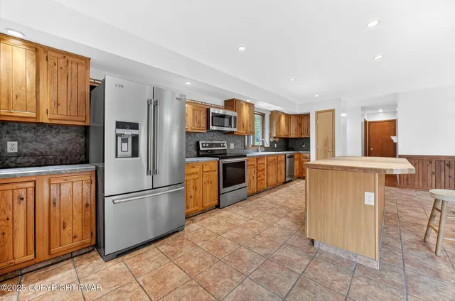 a kitchen with granite countertop a refrigerator and a stove top oven