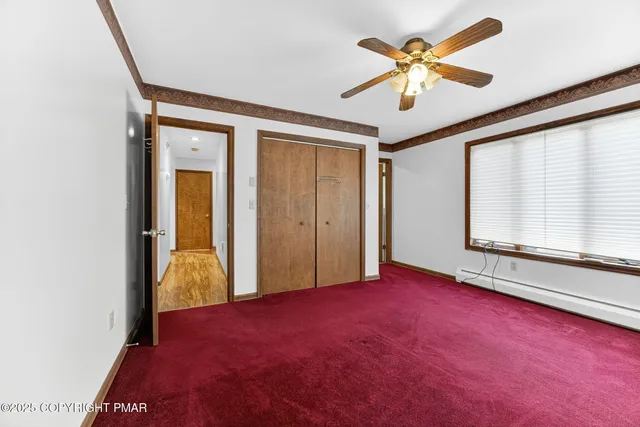 a view of a livingroom with a ceiling fan and window